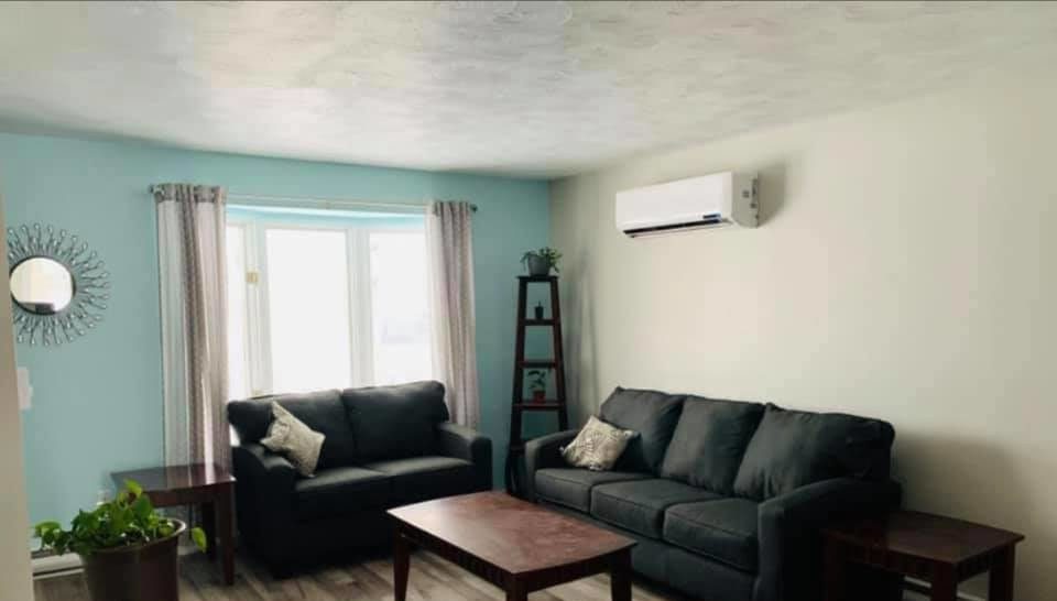 Electrical home improvement - image of a family room with two sofas and air conditioning unit installation